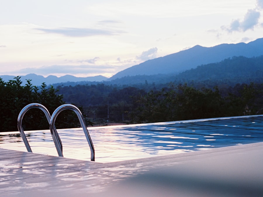 Loungers and palm trees beside a clear blue pool with desert mountains behind.