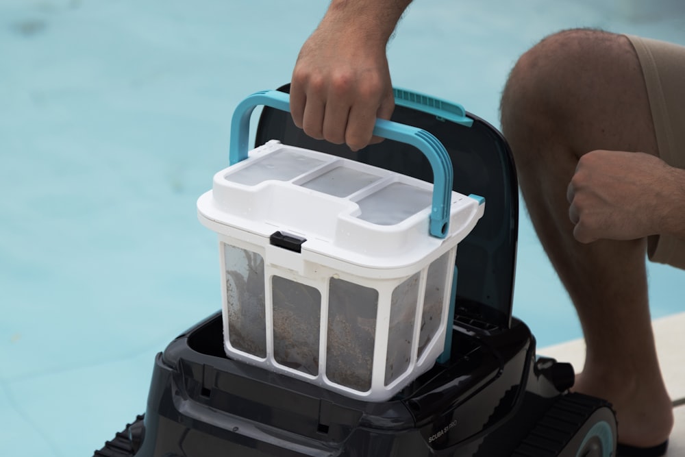 A filter cartridge being lifted out of a pool filter housing for cleaning.